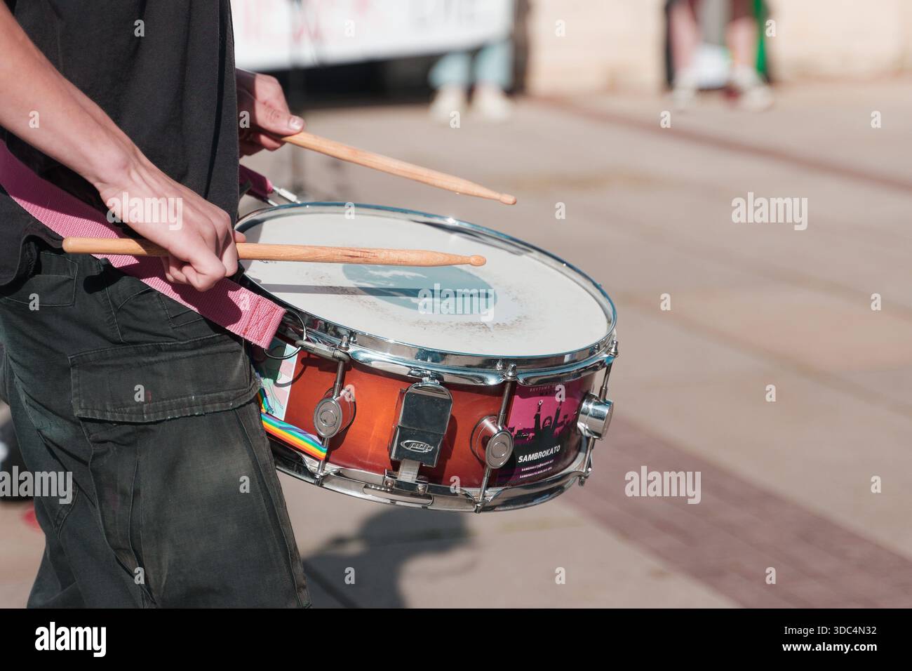 Manifestante pro-Palestina che suona un tamburo rullante durante una dimostrazione vicino al cancello d'ingresso dell'Università di Varsavia. Foto Stock