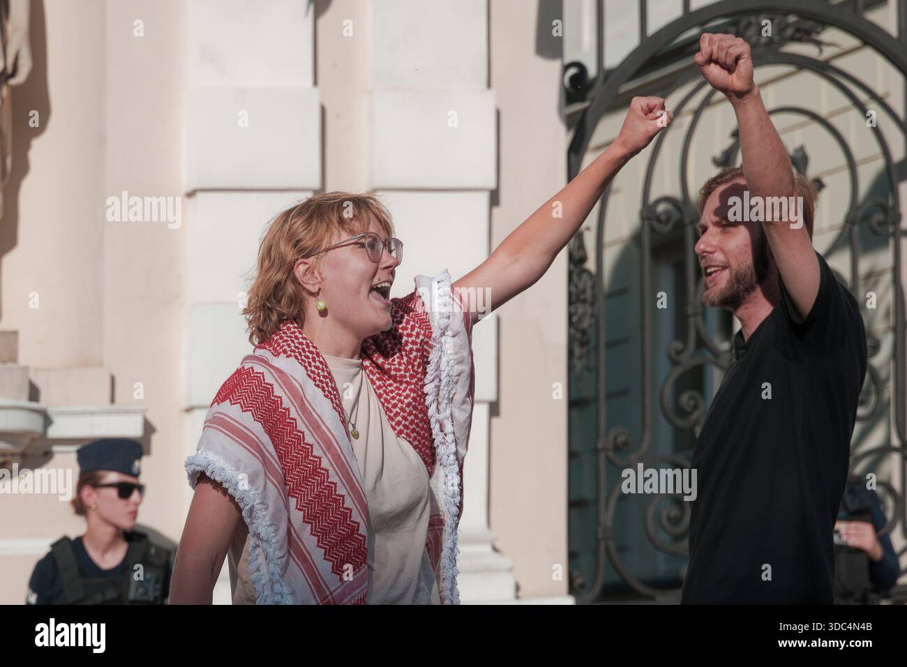 Manifestanti pro-palestinesi che sollevano pugni di solidarietà durante una manifestazione vicino all'ingresso dell'Università di Varsavia. Foto Stock