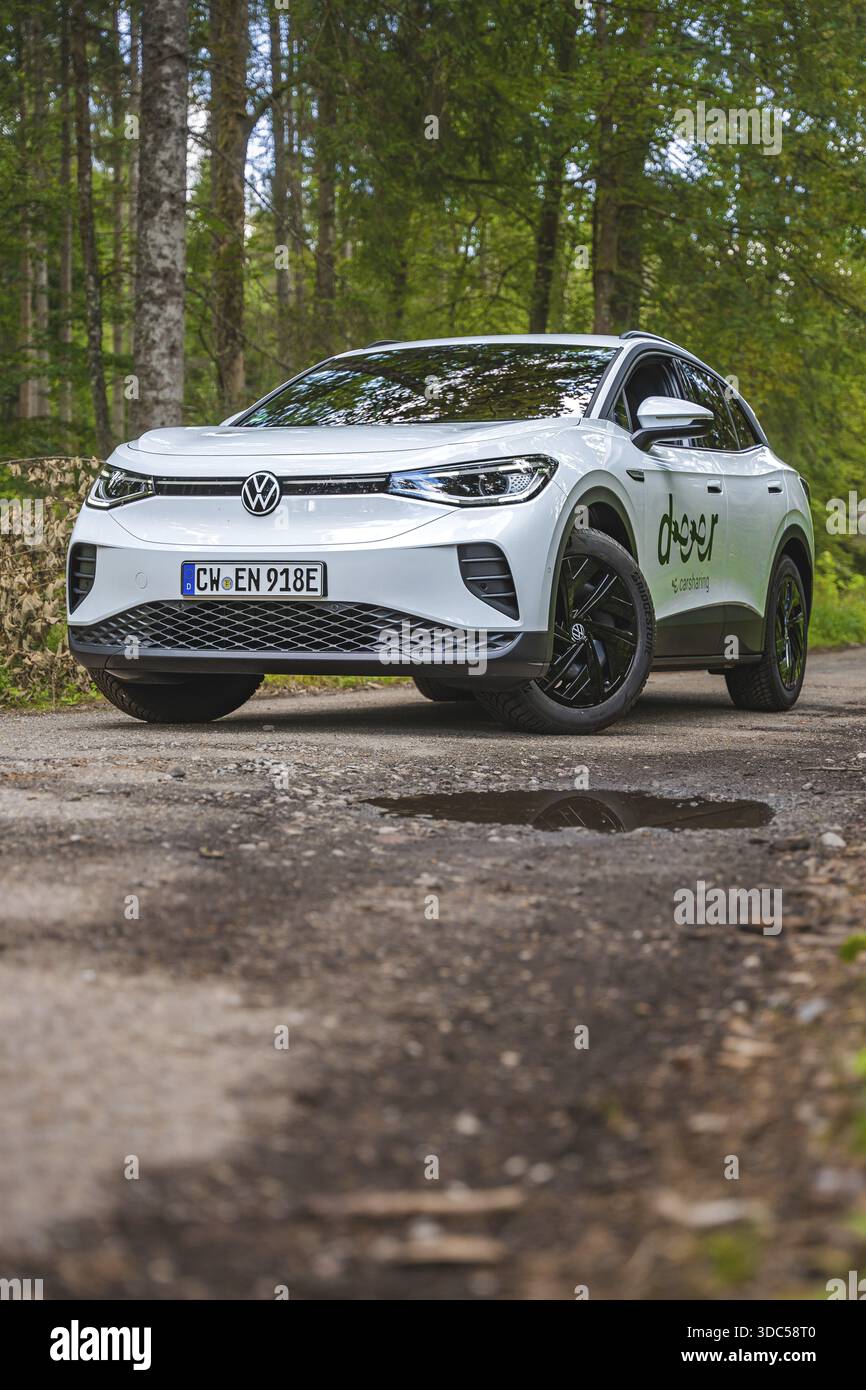 Auto bianca su un sentiero boschivo circondato da alberi, auto elettrica VW ID4, Deer Carsharing, Calw, Germania Foto Stock