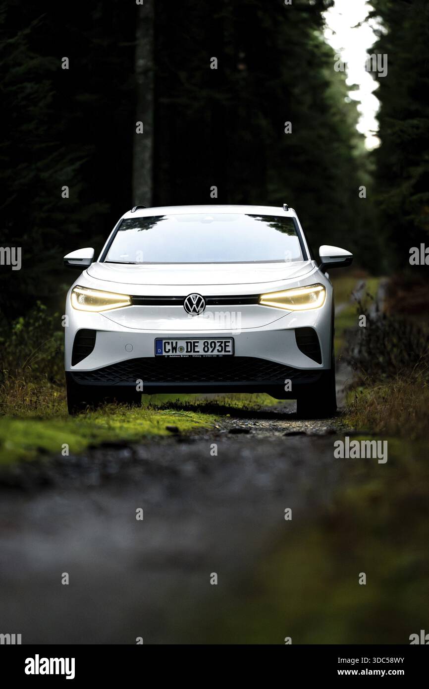 Vista frontale di un'auto su una strada boscosa, auto elettrica VW ID4, Deer Carsharing, Calw, Germania Foto Stock