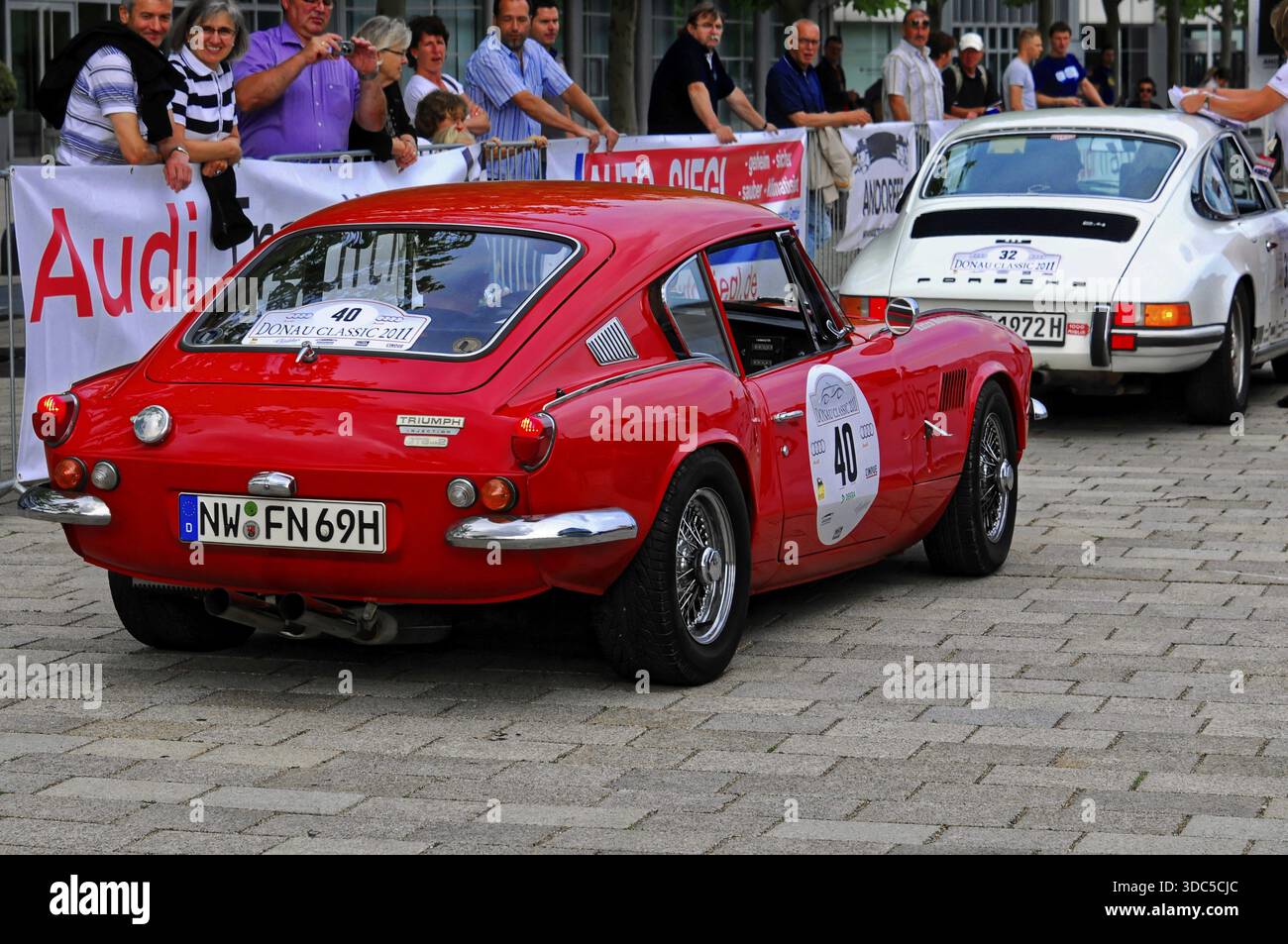 Triumph GT6 MK2, auto d'epoca rossa ad un rally, ammirata dagli spettatori, su strada acciottolata, Danube Classic 2011, Ingolstadt, Baviera, Germania Foto Stock