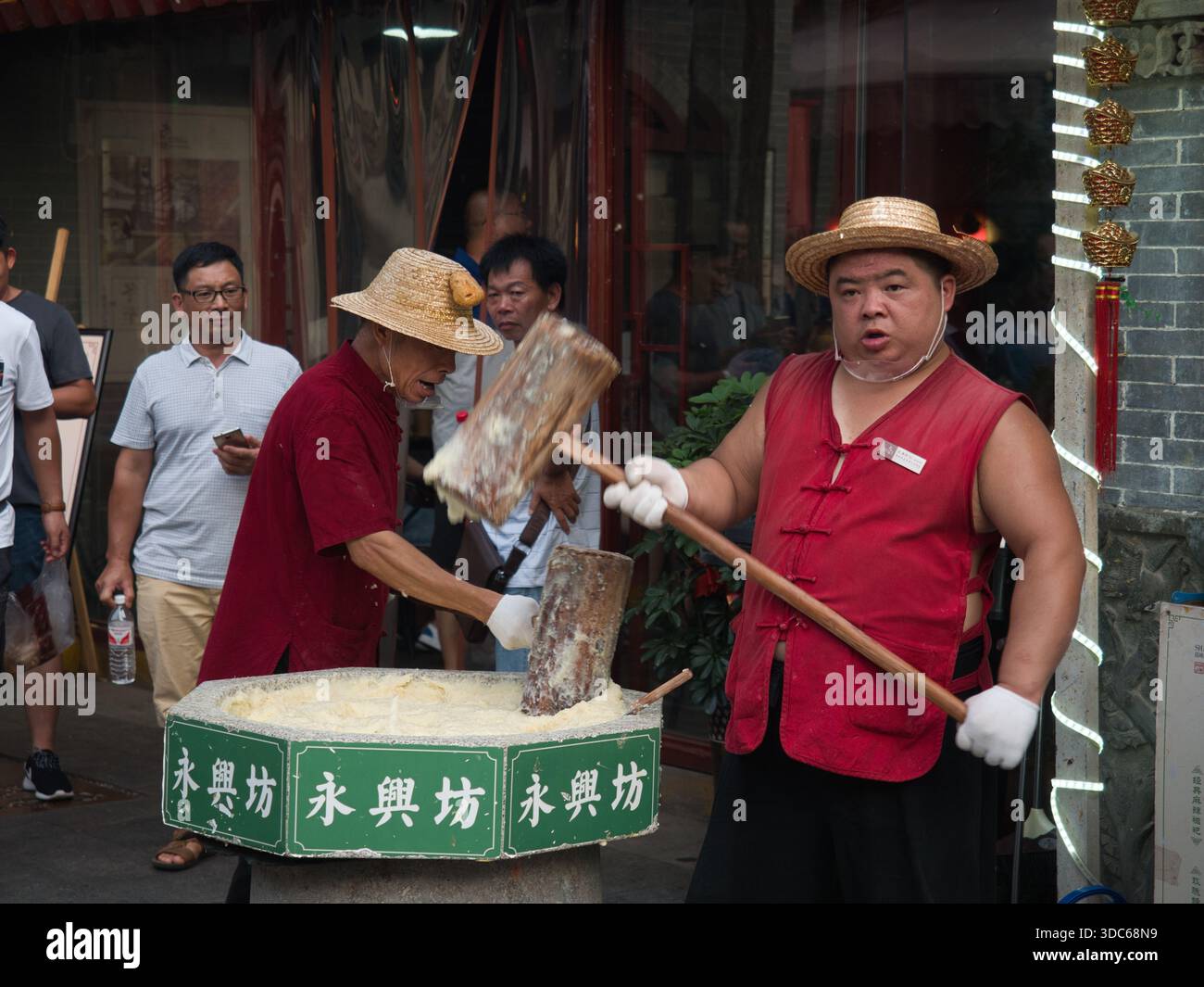 Shanghai-Shanghai-Cina-11 agosto 2018, i venditori ambulanti tradizionalmente pound Ciba (torta di riso appiccicosa) utilizzando grandi mazzuoli di legno a Yongxingfang, un famou Foto Stock
