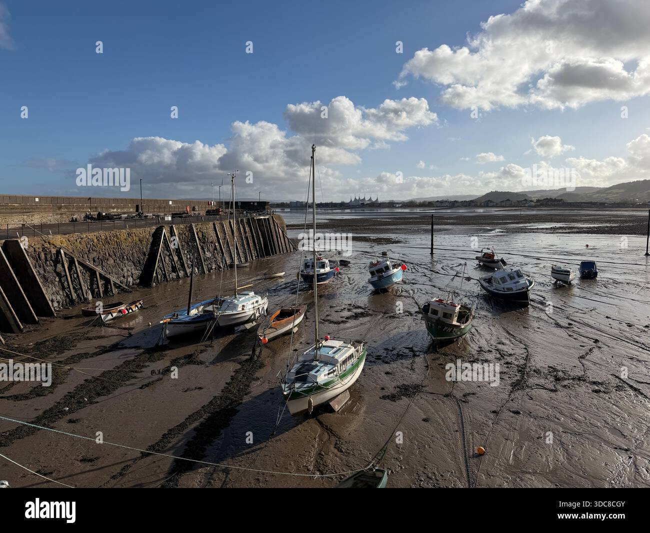 La bassa marea rivela il tranquillo dramma di Minehead Harbour, dove le barche riposanti attendono il ritorno del mare Foto Stock
