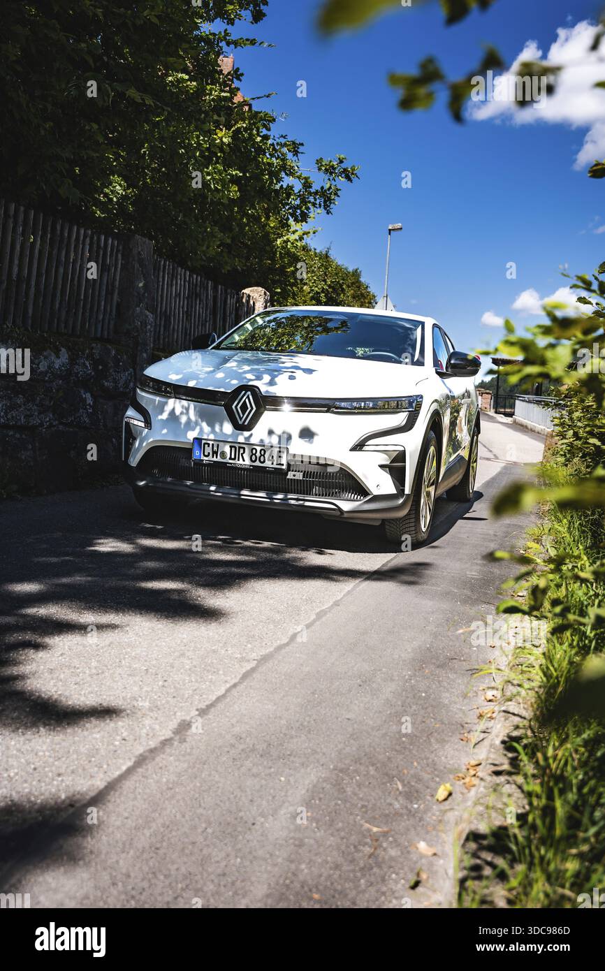 Auto bianca che percorre la strada in una giornata estiva di sole, Deer e-Carsharing, Renault Megane, Calw, Germania Foto Stock