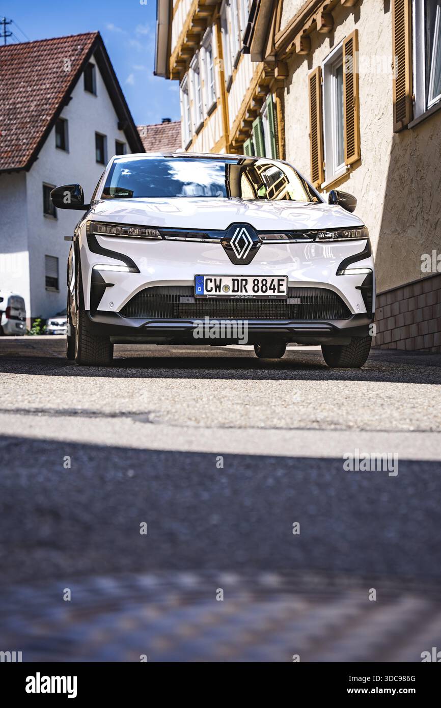 Renault su una strada ombreggiata tra case, Deer e-car sharing, Renault Megane, Calw, Germania Foto Stock