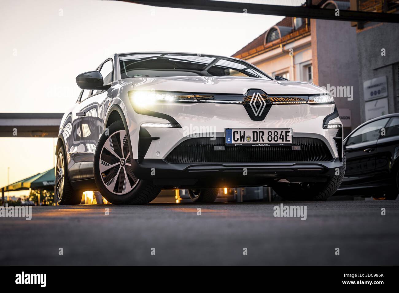 Vista ad angolo basso di una vettura su una strada urbana davanti all'architettura moderna, Deer e-Carsharing, Renault Megane, Calw, Germania Foto Stock
