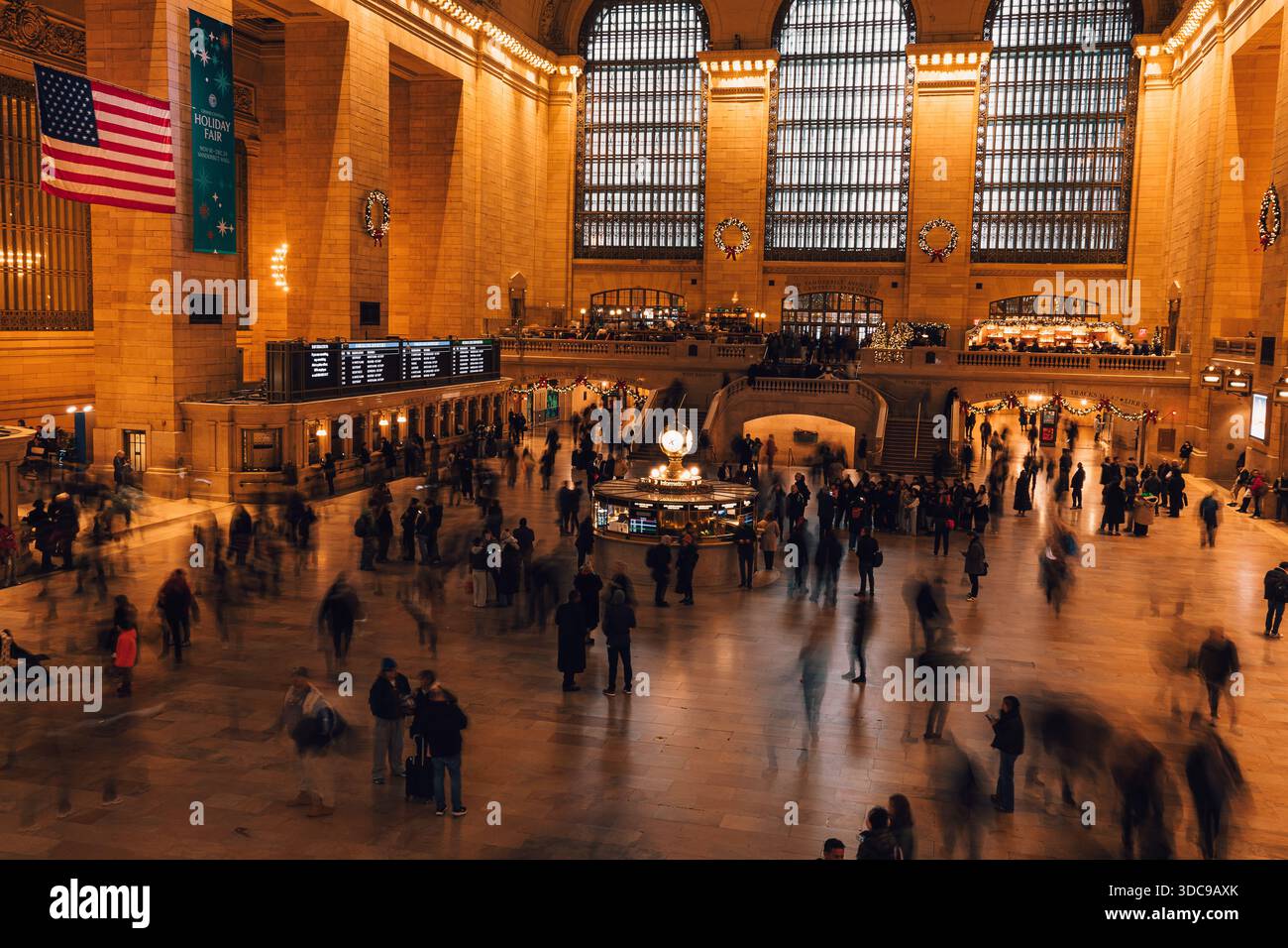 La folla passa attraverso gli interni storici del Grand Central Terminal mentre i viaggiatori navigano verso la stazione di New York City. Foto Stock
