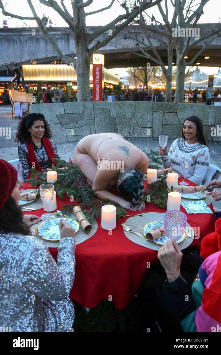 Londra, Regno Unito. 20 dicembre 2025. Un ricciolo umano è stato scambiato con un tacchino consueto su un tavolo di Natale decorato, circondato da cene. Il movimento artistico globale vegano "SpeciesismWTF" ha creato un'installazione artistica sulla South Bank di Londra. L'opera d'arte, intitolata "il pollame non è umano(e)", colloca un essere umano nella posizione di un animale al tavolo della cena di Natale. Essi affermano che, a livello globale, miliardi di uccelli vengono confinati, mutilati e macellati ogni anno per uova e carne. Credito: SOPA Images Limited/Alamy Live News Foto Stock