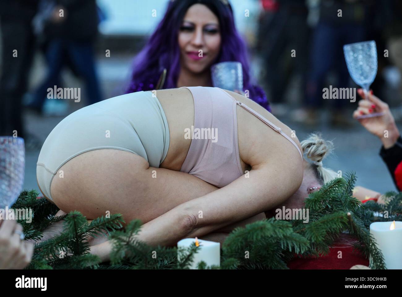 Londra, Regno Unito. 20 dicembre 2025. I commensali alzano i loro bicchieri come un essere umano viene presentato sul tavolo invece che sul pollame durante l'installazione. Il movimento artistico globale vegano "SpeciesismWTF" ha creato un'installazione artistica sulla South Bank di Londra. L'opera d'arte, intitolata "il pollame non è umano(e)", colloca un essere umano nella posizione di un animale al tavolo della cena di Natale. Essi affermano che, a livello globale, miliardi di uccelli vengono confinati, mutilati e macellati ogni anno per uova e carne. Credito: SOPA Images Limited/Alamy Live News Foto Stock