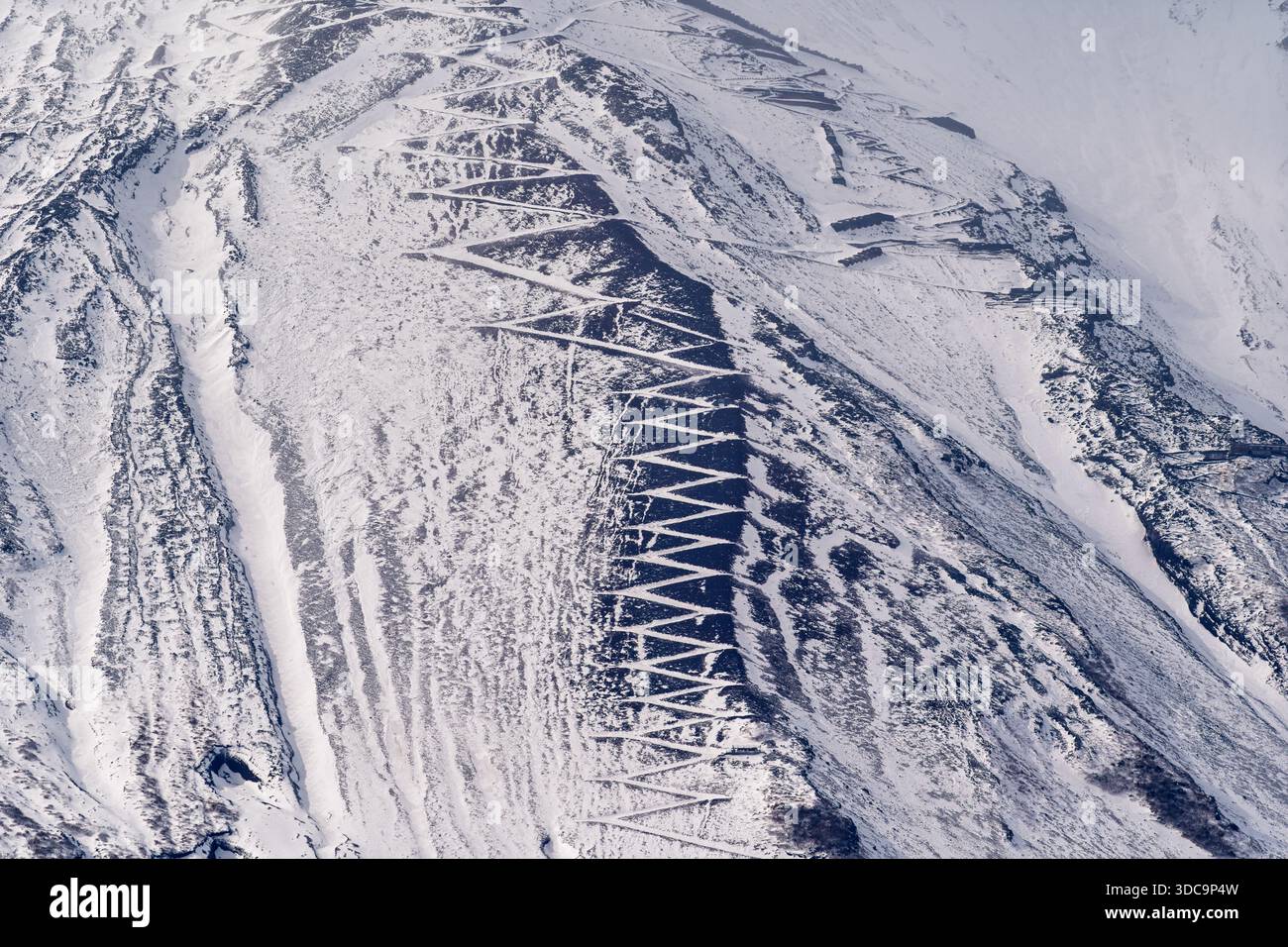 Primo piano del monte Fuji, piste innevate, tornanti avvolgenti, neve strutturata in luce soffusa Foto Stock