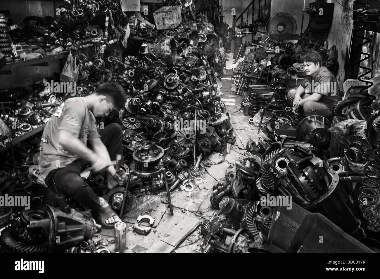 Lavoratori nell'officina di metallo con parti di motori per auto a Bangkok, Thailandia Foto Stock