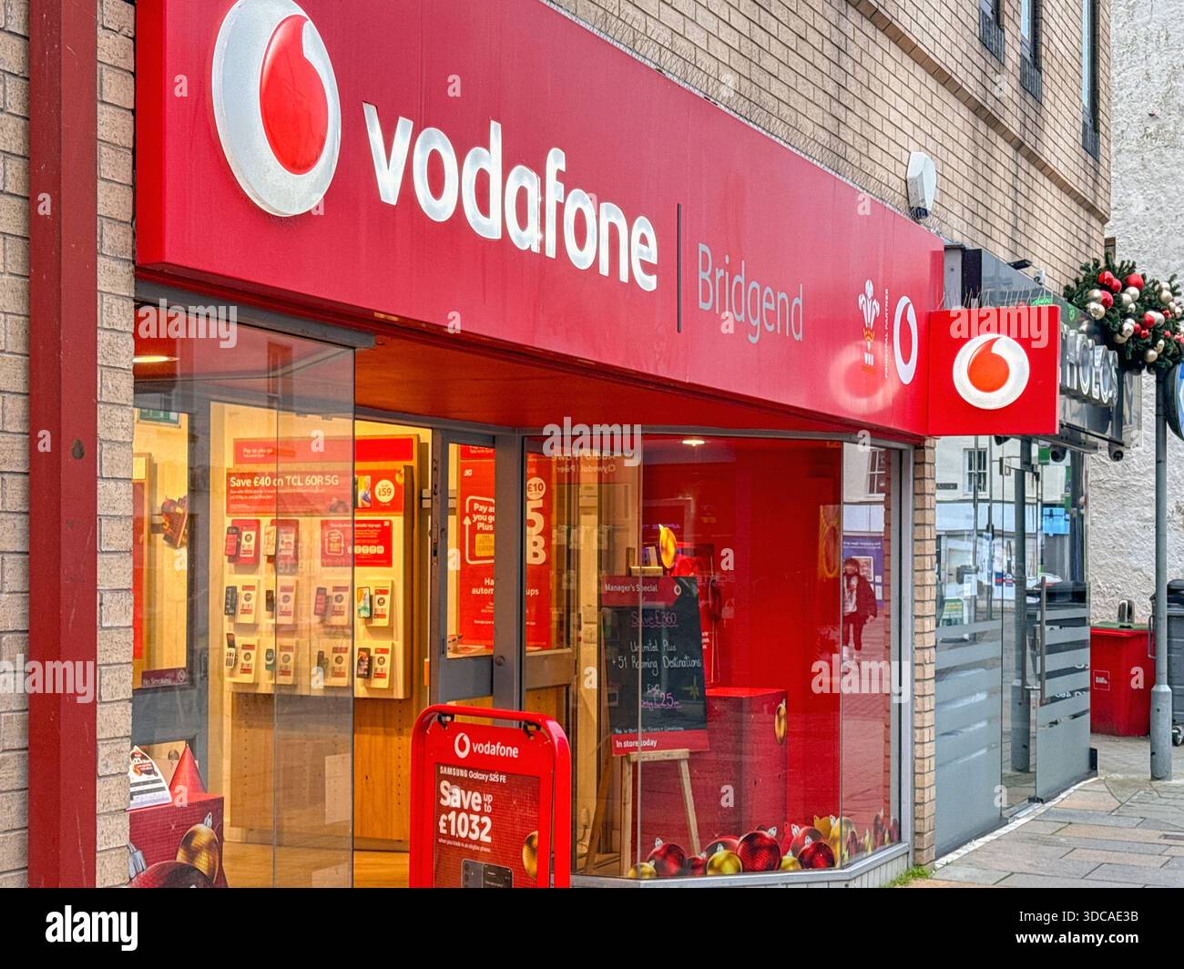 Bridgend, Galles, Regno Unito - 14 dicembre 2025: Vista esterna anteriore del negozio di telefoni cellulari Vodafone nel centro di Bridgend. - Immagine stock catturata con smartphone