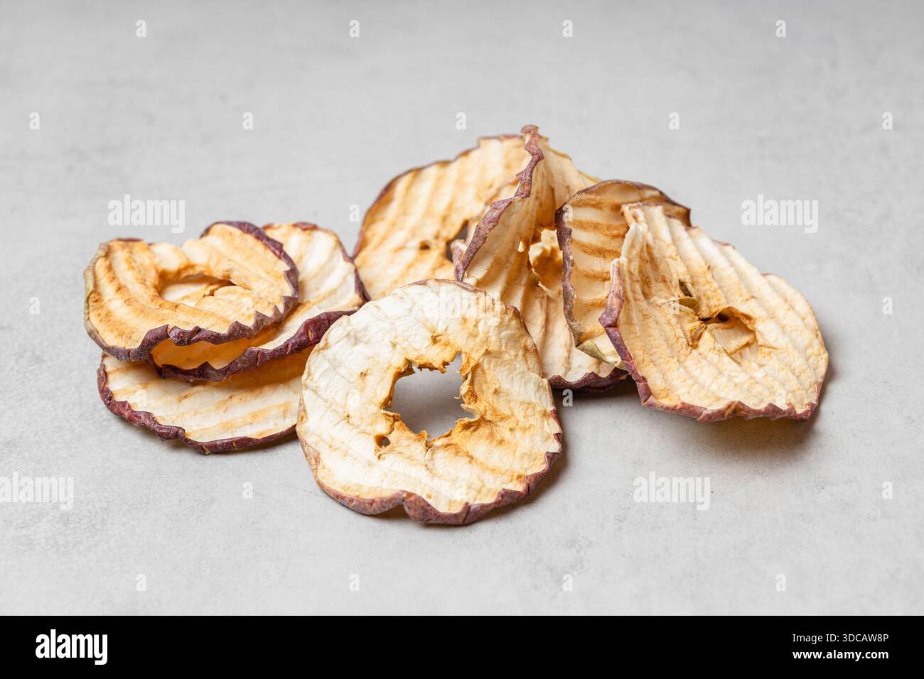 Fette di mela su sfondo grigio chiaro. Uno spuntino sano e delizioso pieno di vitamine. Adatto per vegetariani. Foto Stock