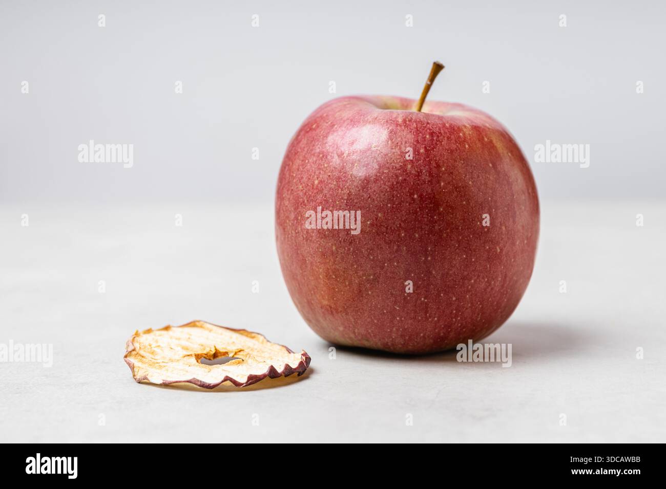 Chip di mele su sfondo grigio chiaro. Uno spuntino sano e delizioso pieno di vitamine. Adatto per vegetariani. Foto Stock