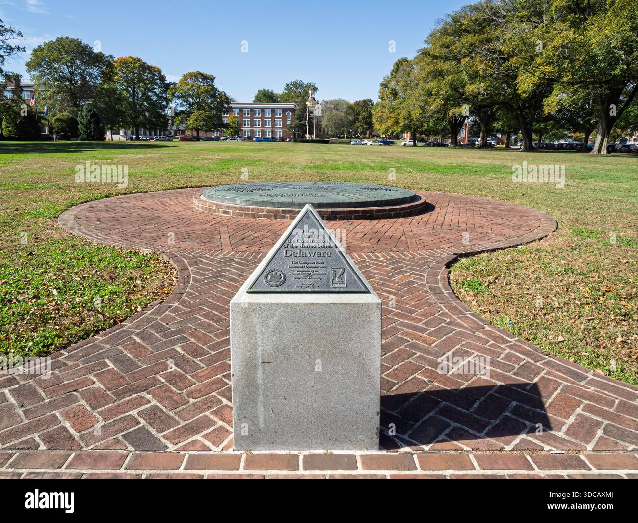 Il primo cartello commemorativo di stato in piedi su una passerella in mattoni con una grande rosa di bussola in bronzo e sala legislativa sullo sfondo del verde Foto Stock