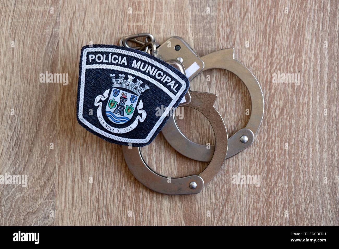 KIEV, UCRAINA - 6 SETTEMBRE 2025 Portogallo patch della polizia municipale e vecchie manette di metallo sul tavolo da vicino Foto Stock