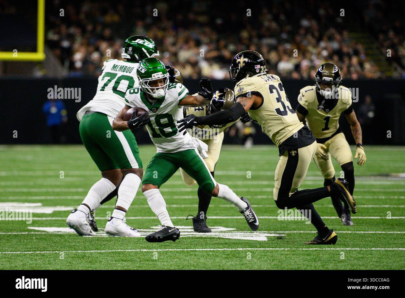 New Orleans, Stati Uniti. 21 dicembre 2025. Il wide receiver dei New York Jets Isaiah Williams (18) tentò di stringere il braccio della safety dei New Orleans Saints Jonas Sanker (33) durante il primo tempo di una partita di football al Caesars Superdome di New Orleans, LOUISIANA, domenica 21 dicembre 2025. Foto di Paul Kieu/UPI credito: UPI/Alamy Live News Foto Stock