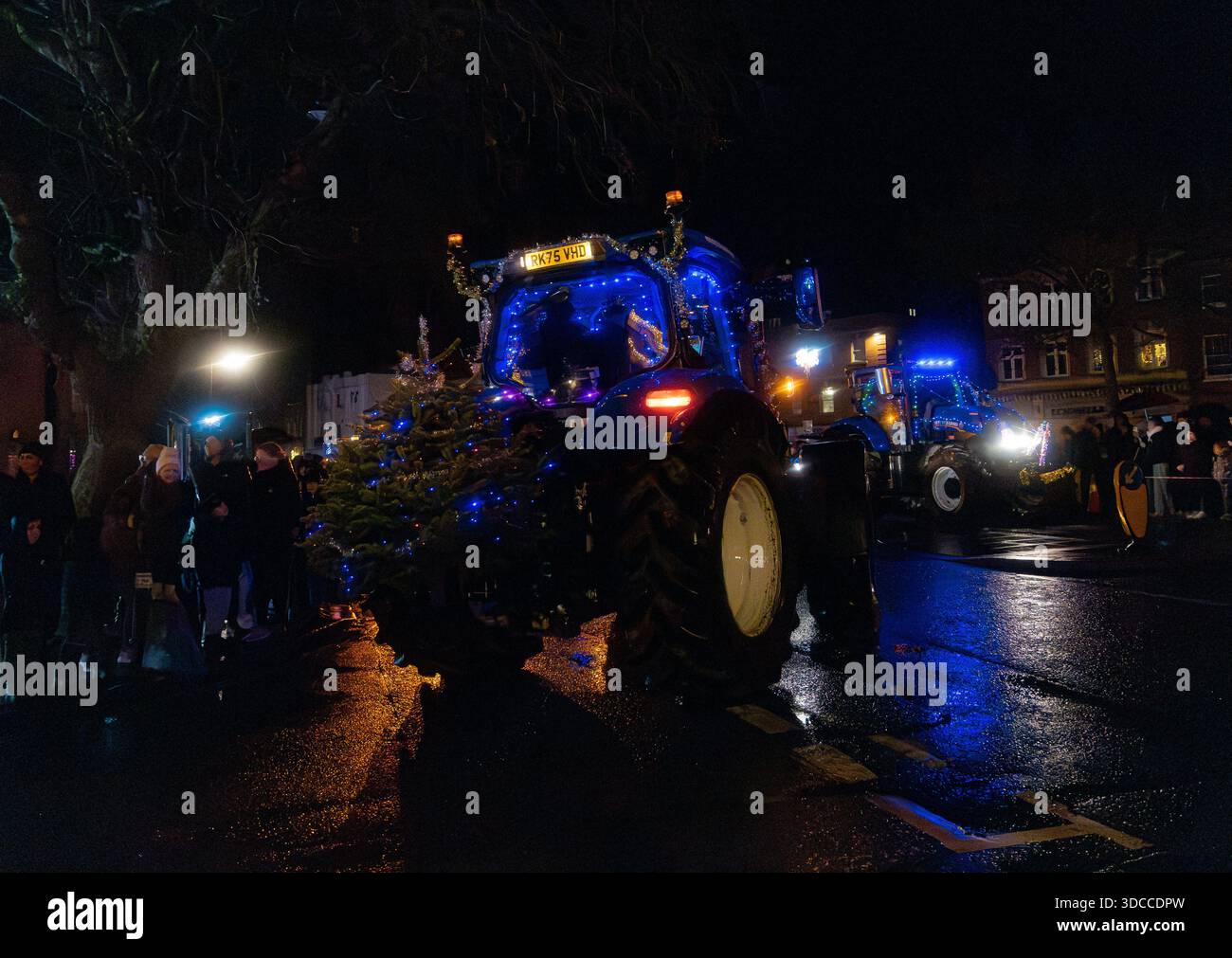 Trattori decorati con luci di Natale e un albero di Natale illuminato in una sfilata festosa di notte Tractors and Tinsel corrono a Devizes il 21 dicembre 2025 Foto Stock