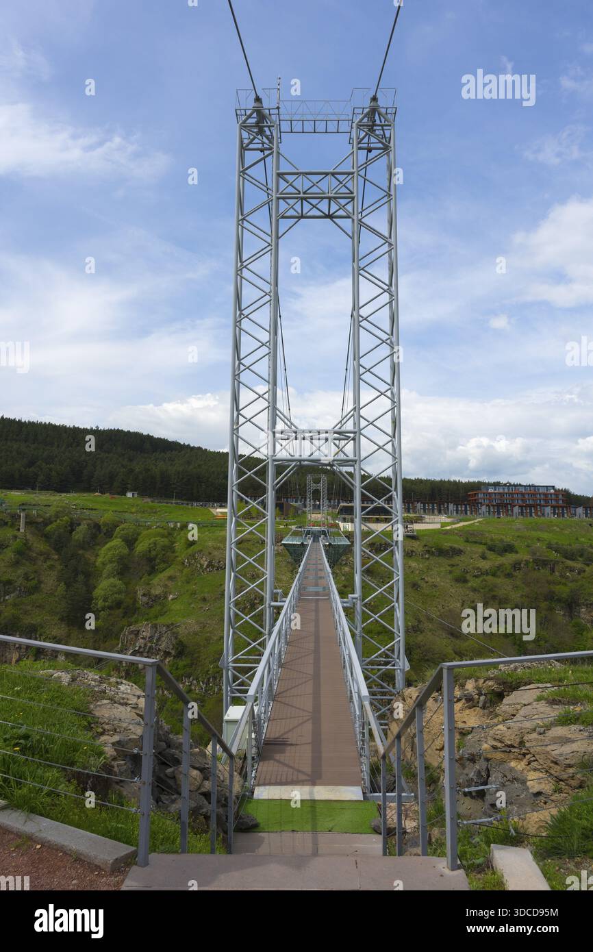 Vista di un alto ponte sospeso con travi in acciaio contro il cielo blu, Diamond Bridge, Diamond Glass Bridge, la struttura sospesa più lunga del mondo Foto Stock