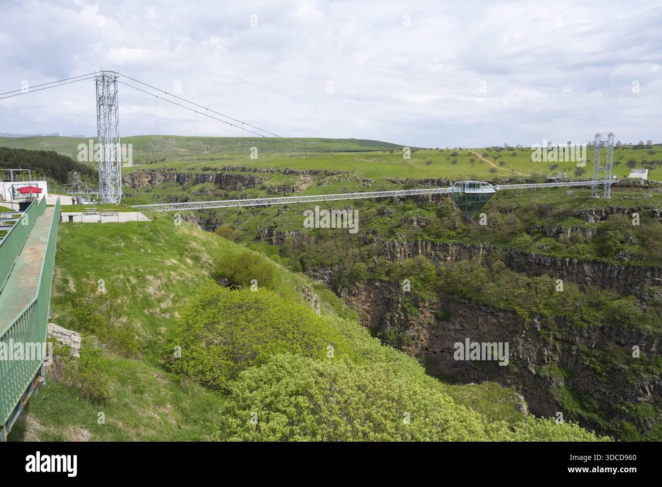 Ampio paesaggio con moderno ponte sul verde, gola rocciosa sotto il cielo nuvoloso, Diamond Bridge, Diamond Glass Bridge, la struttura sospesa più lunga del mondo Foto Stock