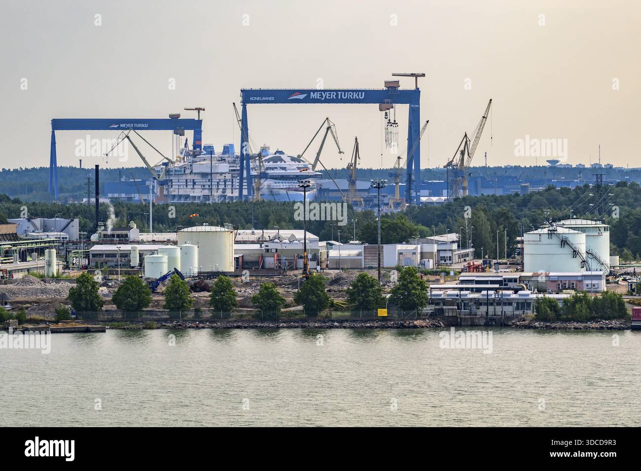 Zona portuale industriale con gru e cantieri navali sull'acqua, Meyer Werft, Turku, Finlandia Foto Stock
