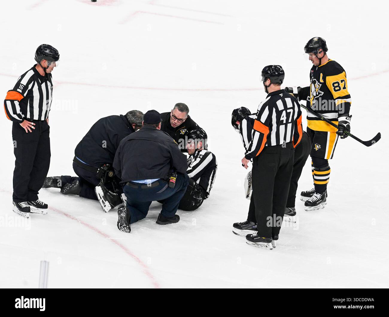 Pittsburgh, Stati Uniti. 21 dicembre 2025. Paramedic viene in aiuto di Linesperson Ryan Jackson (84) come il centro dei Pittsburgh Penguins Sidney Crosby (87) guarda durante il secondo periodo alla PPG Paints Arena di Pittsburgh domenica 21 dicembre 2025. Foto di Archie Carpenter/UPI. Crediti: UPI/Alamy Live News Foto Stock