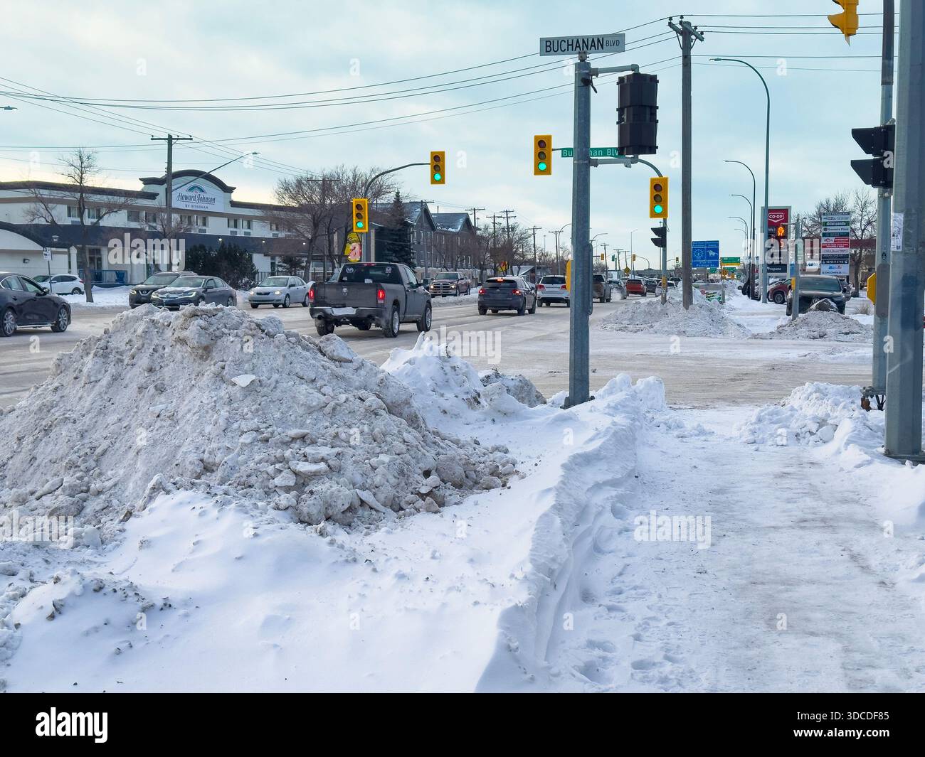 Winnipeg Street dopo la severa Blizzard.Urban Road a Winnipeg dopo una potente bufera di neve e una forte nevicata. Enormi banchi di neve fiancheggiano la strada mentre si sfrecciano Foto Stock