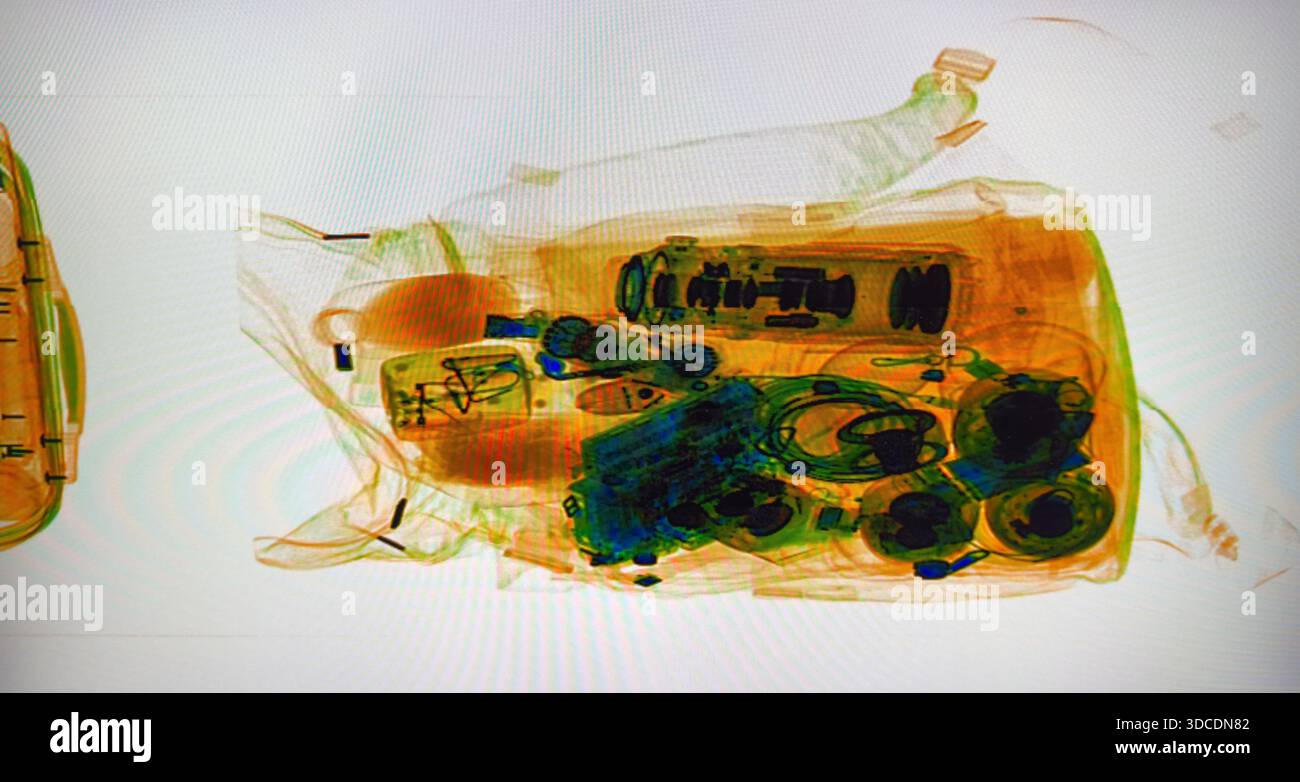 La borsa trasparente sullo scanner a raggi X rivela monete e oggetti di uso quotidiano al checkpoint di sicurezza. Una visione informativa dello screening dei bagagli che mette in evidenza il processo di ispezione e le misure di sicurezza. Foto Stock