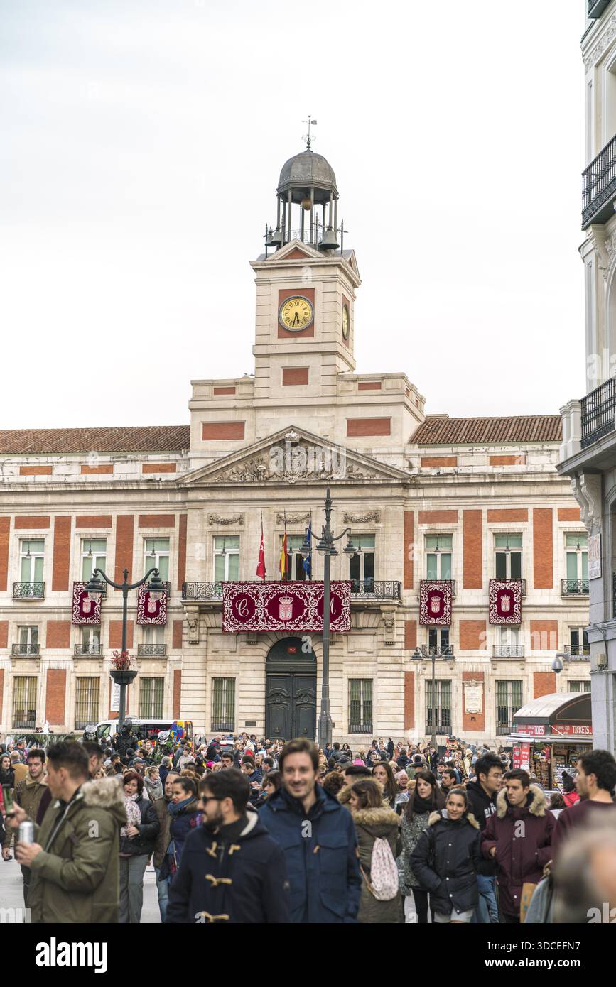 Madrid, Spagna - 9 novembre 2016: Vista della storica Casa de Correos inondata di luce soffusa, la sua torre dell'orologio che perfora il cielo sopra una folla affollata. Foto Stock