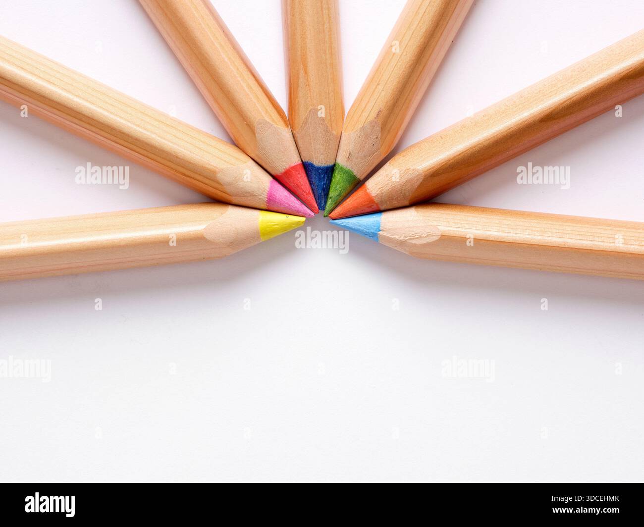 Set di matite colorate che creano un cerchio su sfondo bianco, ideale per concetti educativi o artistici Foto Stock