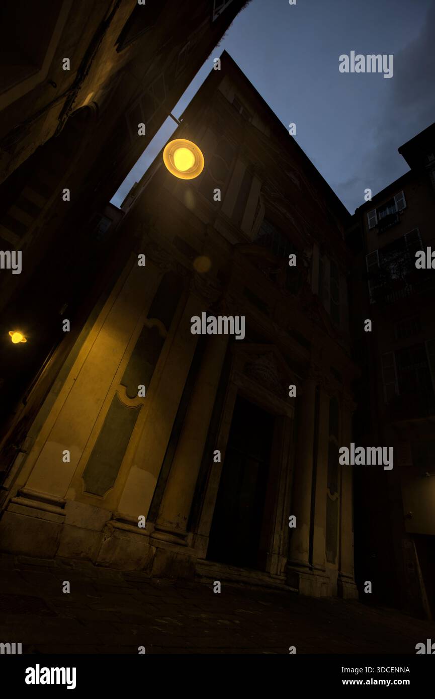 Facciata di una chiesa e di un lampione stradale sospeso con il cielo crepuscolo sullo sfondo Foto Stock
