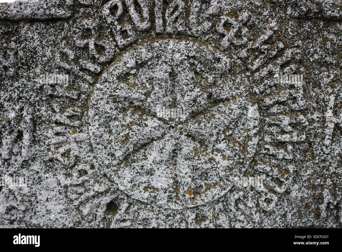 Profondità di campo bassa (messa a fuoco selettiva) dettagli con iscrizioni e consistenza di una vecchia croce cristiana ortodossa in pietra. Foto Stock
