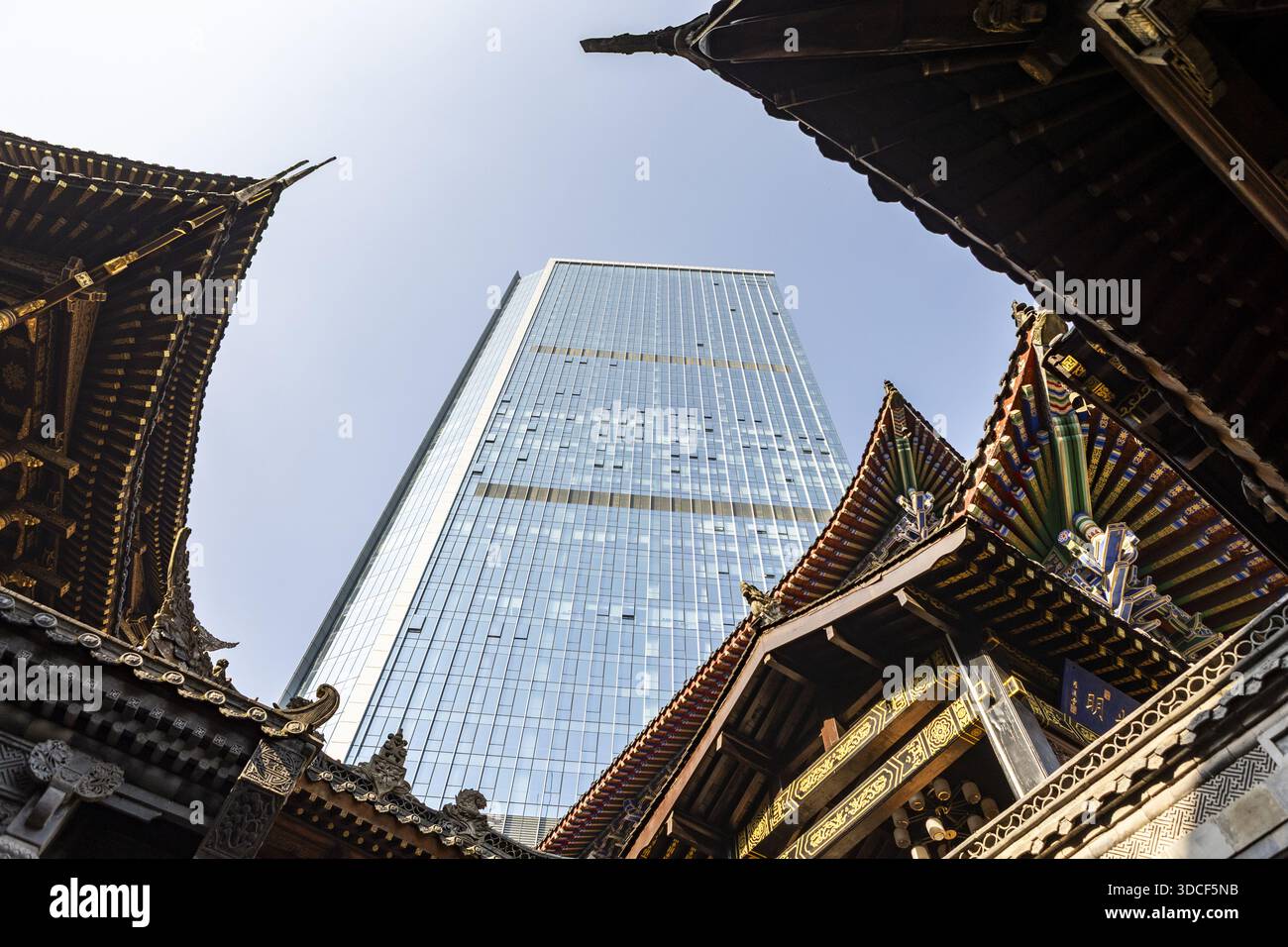 Vista di un moderno grattacielo incorniciato da ornate e tradizionali grondaie di antichi edifici, una fusione di passato e futuro, Chongqing, Chongqing, chi Foto Stock