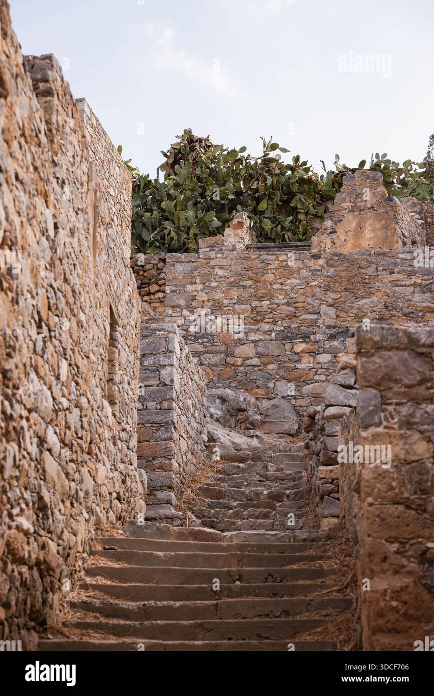 Antica scalinata in pietra tra le mura della fortezza sull'isola di Spinalonga, Creta, Grecia. Rovine storiche della fortificazione veneziana con architettura difensiva. Foto Stock