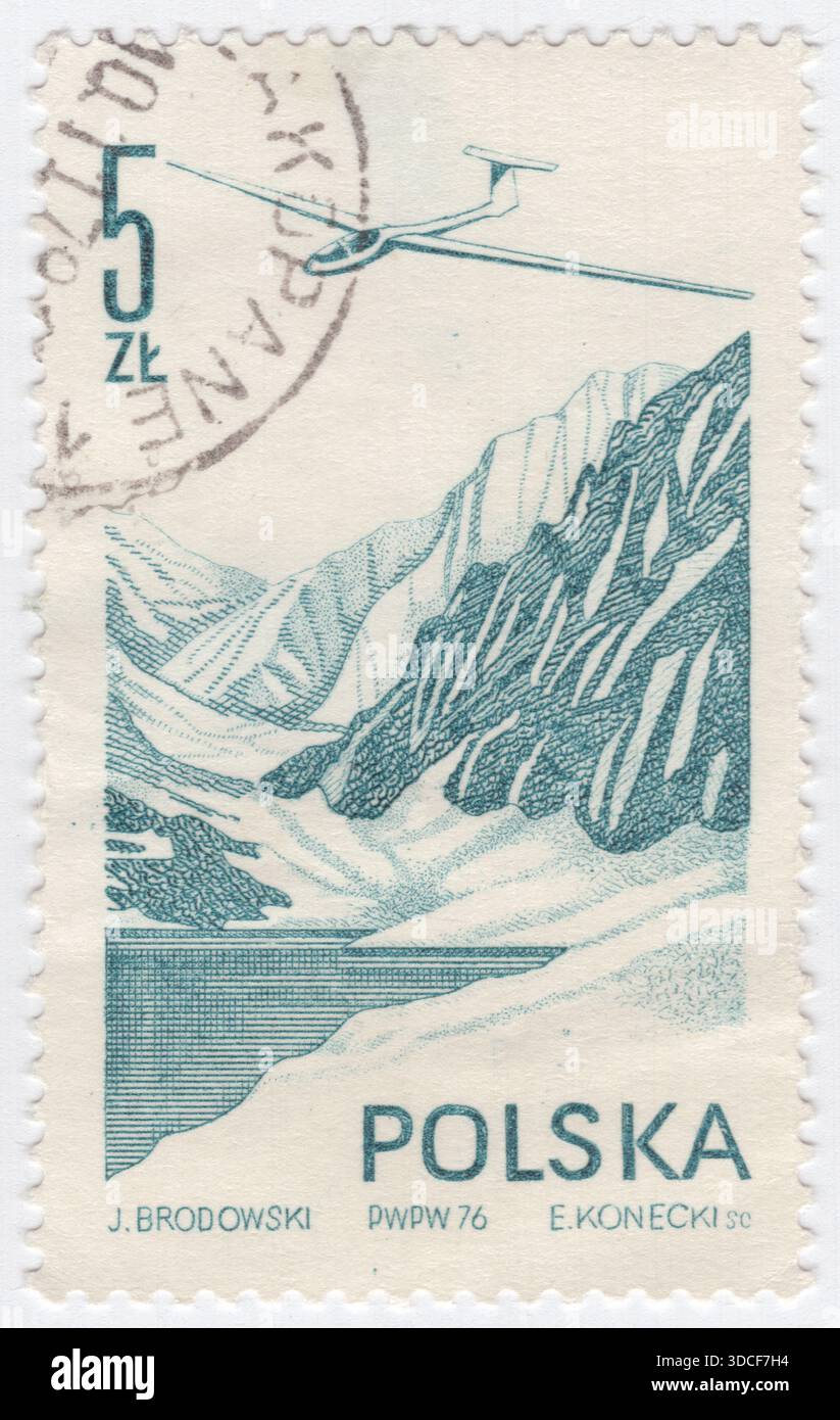 POLONIA — 1976 marzo 27: Francobollo Air Post blu-verde di 5 zloty raffigurante Jantar Glider sopra un lago di montagna. L'SZD-38 Jantar 1 (ambra) è un aliante progettato e prodotto in Polonia dal 1971. La posta aerea (posta aerea) è un servizio di trasporto postale marchiato e venduto sulla base di almeno una tappa del suo viaggio per via aerea. Gli articoli per posta aerea in genere arrivano più rapidamente della posta di superficie e di solito costano di più per l'invio Foto Stock