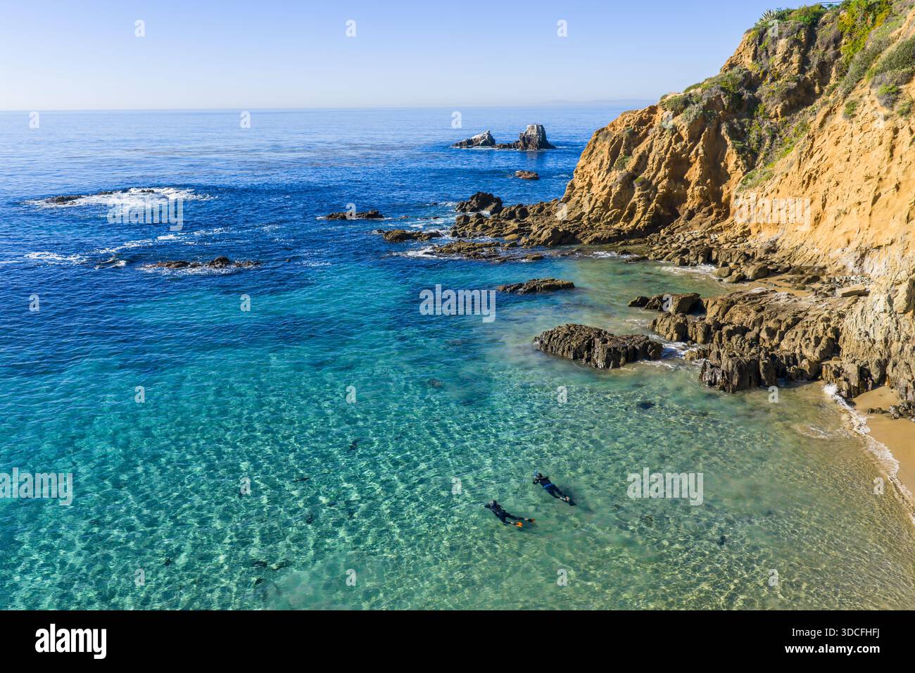 Vista aerea delle acque turchesi che incontrano dolcemente la spiaggia sabbiosa vicino alle scogliere rocciose, in contrasto con l'oceano blu profondo, Laguna Beach, California, Foto Stock