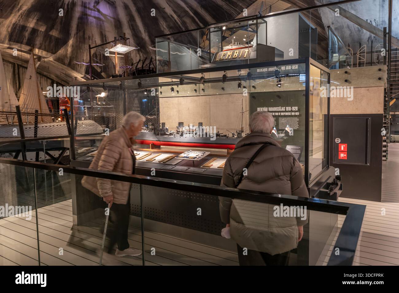La gente guarda la mostra con il modello di nave da guerra nel porto degli idrovolanti dell'interno del Museo marittimo estone a Tallinn, Estonia. Foto Stock