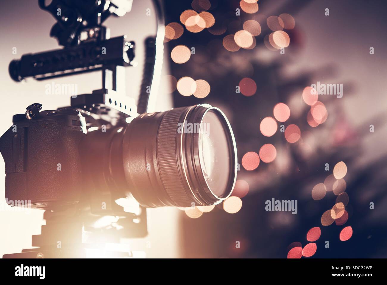 Una fotocamera è montata su un treppiede per scattare foto di uno spazio decorato con luci. Foto Stock