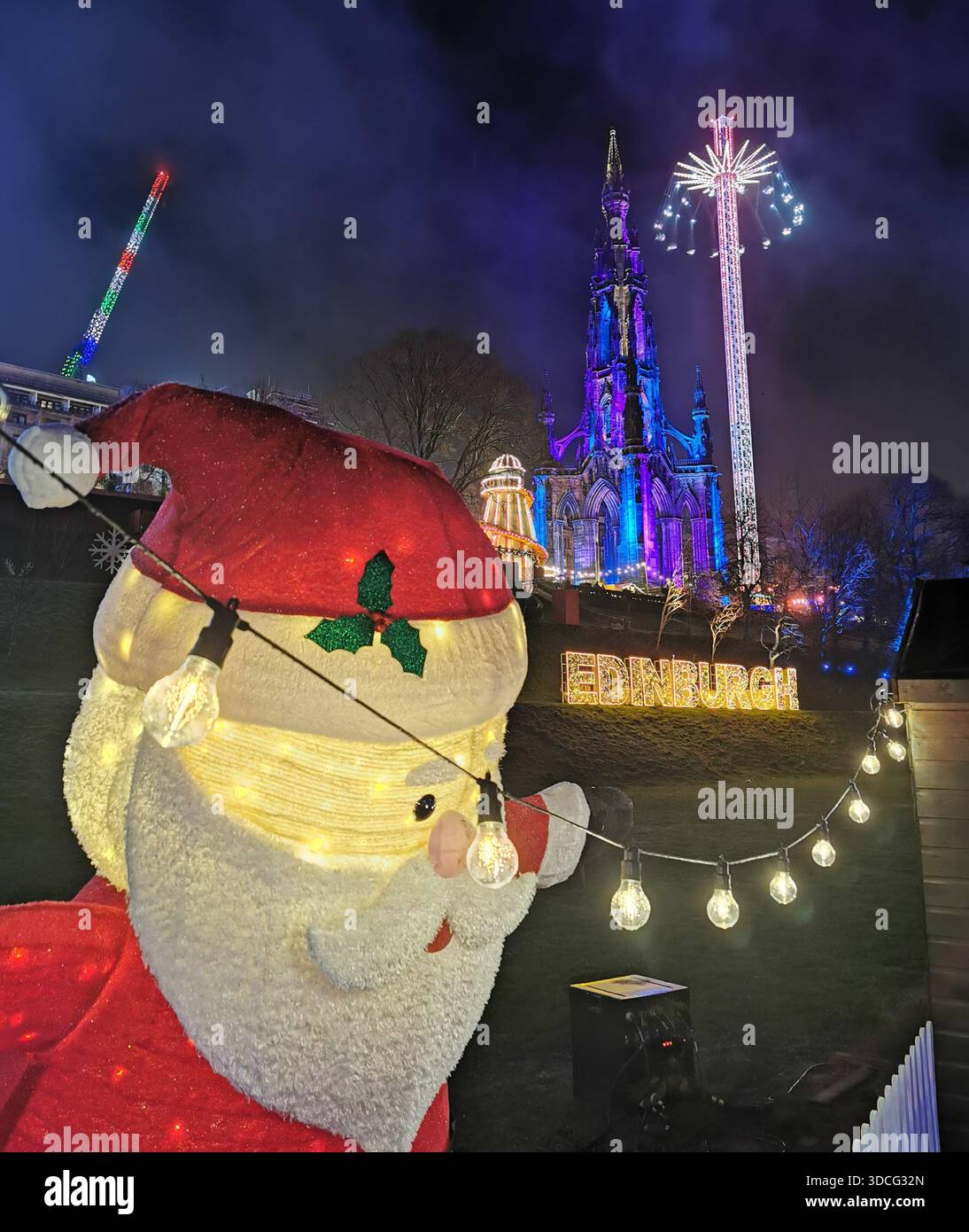 Scene festive dal mercato di Natale di Edimburgo con bancarelle luminose, edifici illuminati e un gigantesco cartello illuminato di Edimburgo che creano una scena vivace. - Immagine stock catturata con smartphone