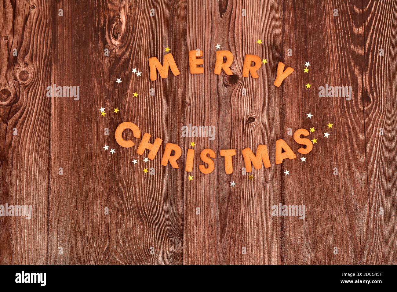 Ottimi biscotti natalizi e stelle festive su sfondo di legno scuro. Vista dall'alto, copia spazio. Sfondo natalizio. Foto Stock