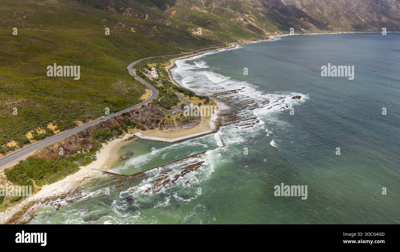Vista aerea della costa frastagliata dove le onde oceaniche si scontrano con le coste rocciose vicino a Rooi-Els, Capo Occidentale, Sud Africa. Foto Stock