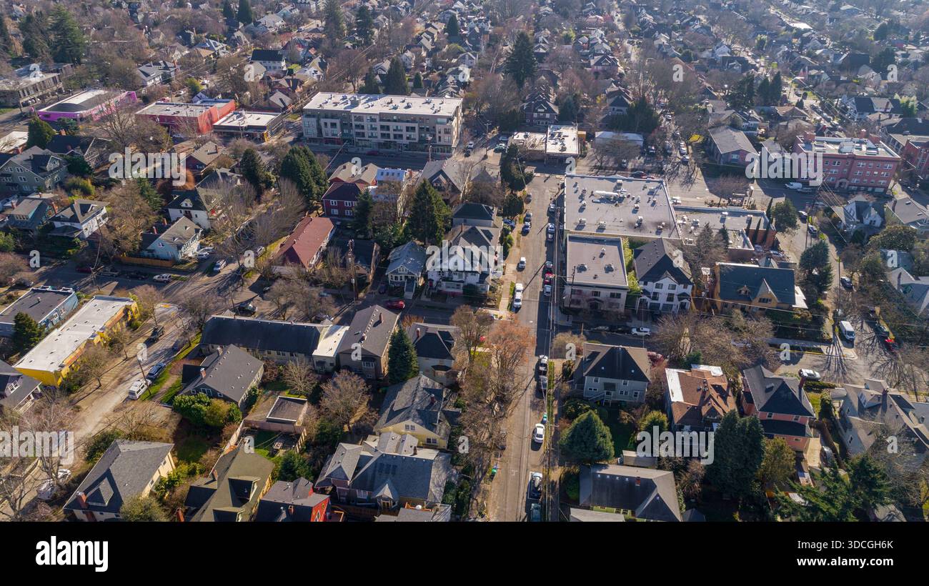 Vista aerea dei tetti e delle tettoie degli alberi intervallate da edifici lungo la 23a strada sudorientale, che gettano lunghe ombre nella fresca luce mattutina, po Foto Stock