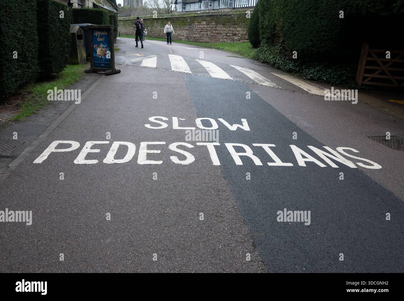 Cartello per pedoni lenti, vialetto di Warwick Castle, Warwickshire, Regno Unito Foto Stock