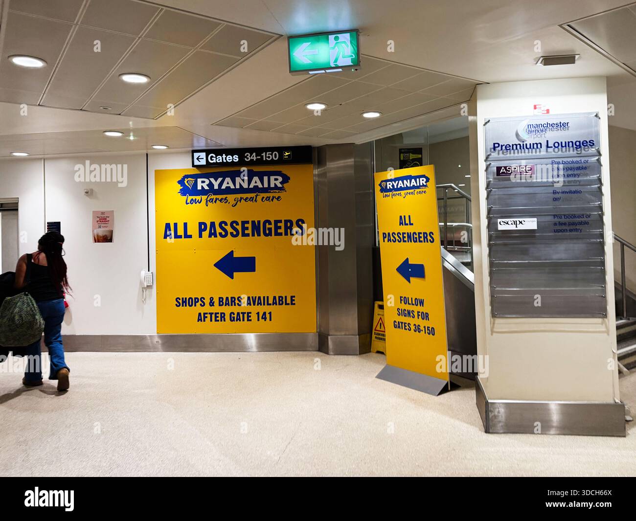 Manchester, Regno Unito - 13 dicembre 2025: La segnaletica gialla Ryanair indirizza i passeggeri verso i cancelli e i negozi all'interno dell'aeroporto di Manchester. Foto Stock