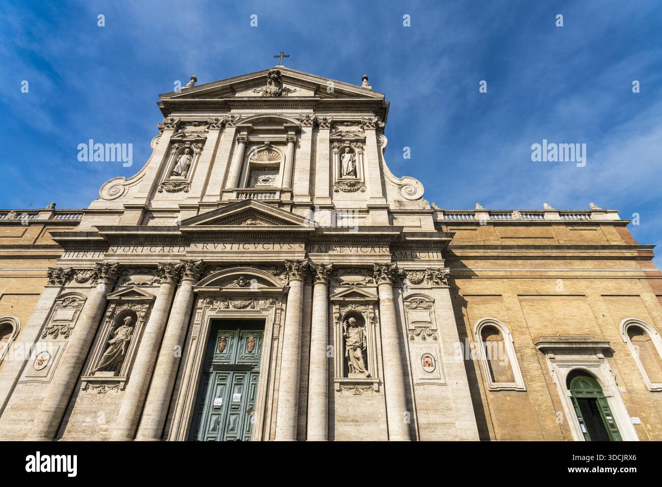 La vista della basilica papale di Santa Maria maggiore si erge maestosamente sotto un cielo blu luminoso, con la sua facciata pallida adornata con statue e intricate sculture Foto Stock
