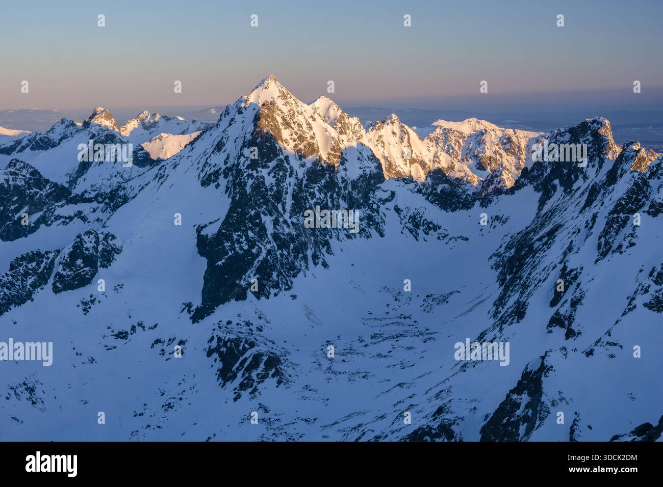 Vista aerea delle montagne innevate immerse nella luce dorata del sole, Koncista, regione di Presov, Slovacchia. Foto Stock
