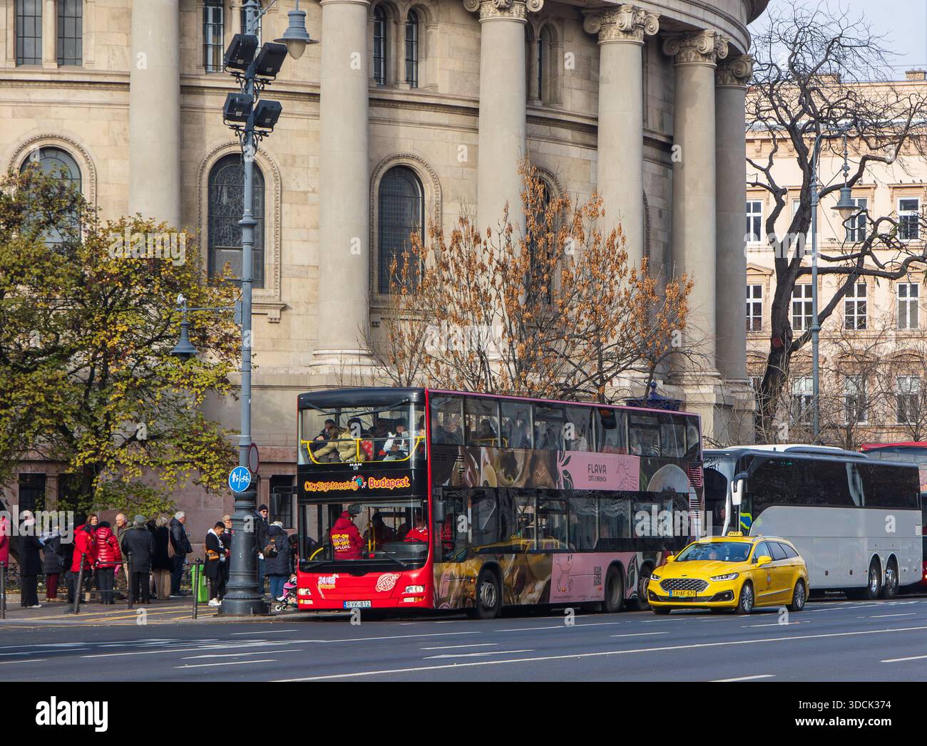 Budapest, Ungheria - 24 ottobre 2025: Autobus a due piani Red City Sightseeing presso la Basilica di Santo Stefano Foto Stock
