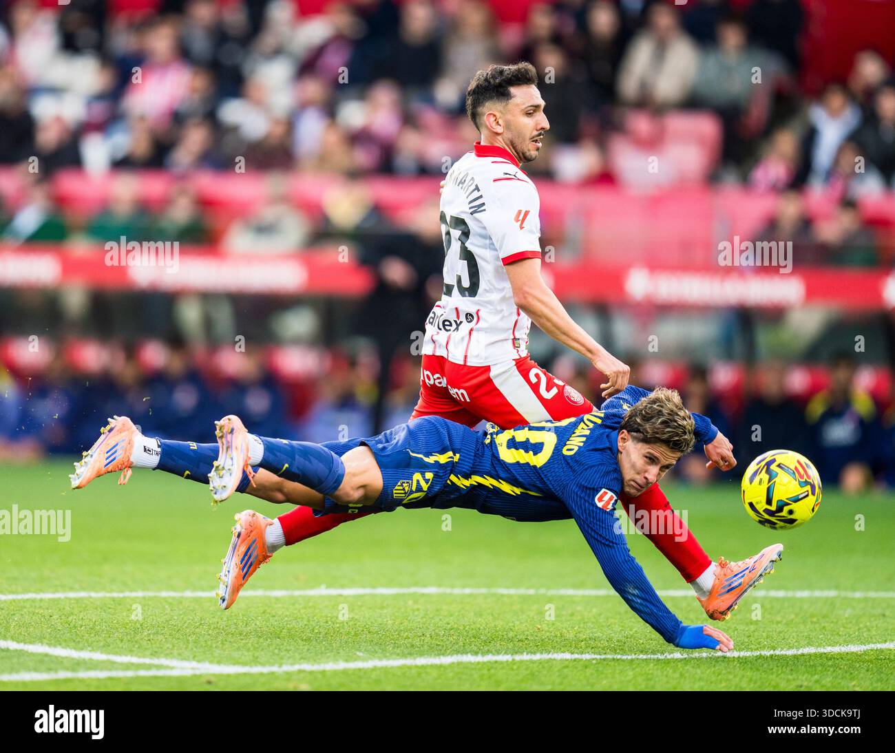 (251223) -- PECHINO, 23 dicembre 2025 (Xinhua) -- Giuliano Simeone (in basso) dell'Atletico de Madrid vies con Ivan Martin del Girona FC durante la partita di calcio della Liga tra Girona FC e Atletico de Madrid allo Stadio Montilivi, Girona, Spagna, il 21 dicembre 2025. (Foto di Joan Gosa/Xinhua) Foto Stock