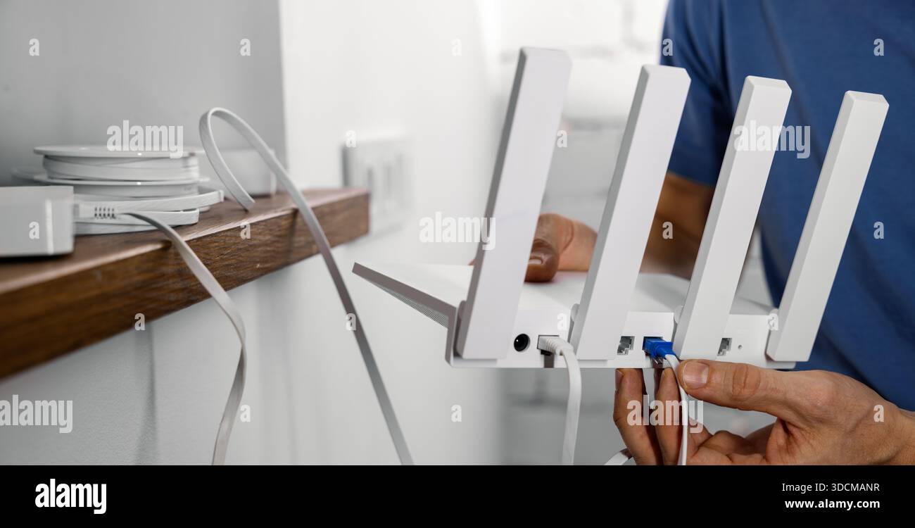 Internet wireless. Il tecnico del provider di servizi collega i cavi al router Wi-Fi. copia spazio Foto Stock