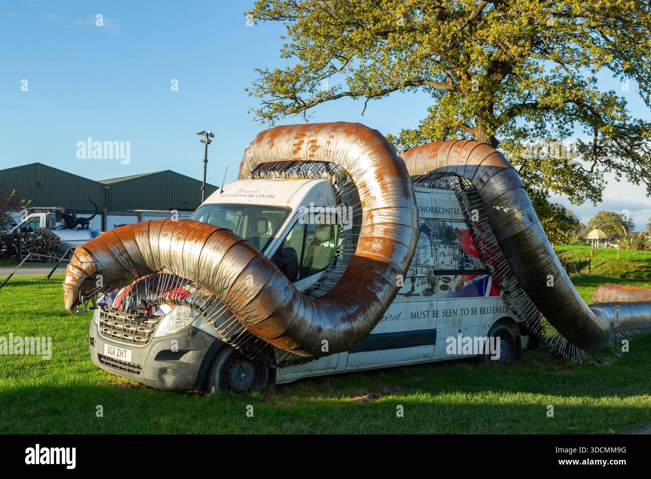 Una scultura di un gigantesco millipede africano che si arrampica su un furgone British ironwork Centre, Oswestry, Shropshire, Inghilterra Foto Stock